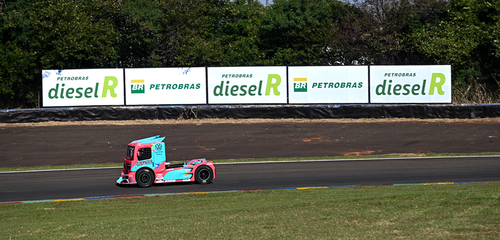 caminhão rosa e azul em pista de corrida com placa de diesel R e Petrobras