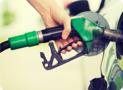 Hand fueling a car with a green gas pump nozzle.