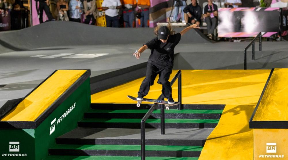 Skateboarding athlete performing a trick on a railing.