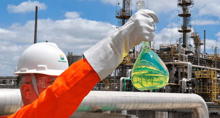 Mão de funcionário da Petrobras, vestindo luva, exibe um fraco com diesel R.