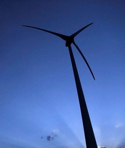 Turbina eólica contra o céu azul ao entardecer.