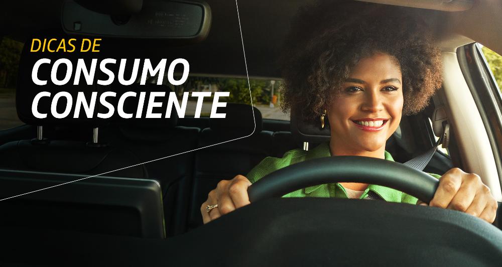 Fotografia dentro de um carro, mostrando uma mulher sorrindo enquanto dirige. Ao lado dela está o texto “Dicas de consumo consciente”.